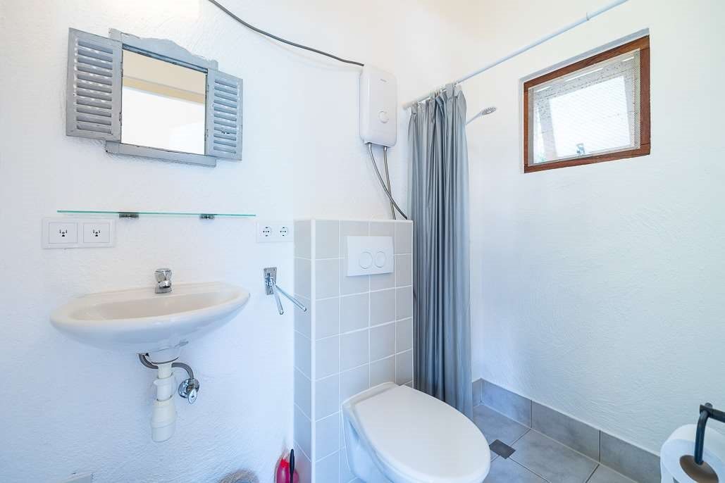 Badkamer van de studio met wastafel, toilet en douche